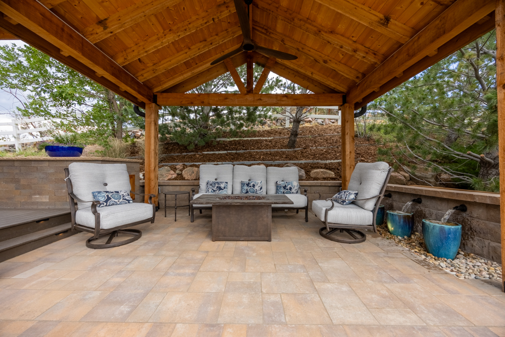 A pergola with a sitting area and water feature